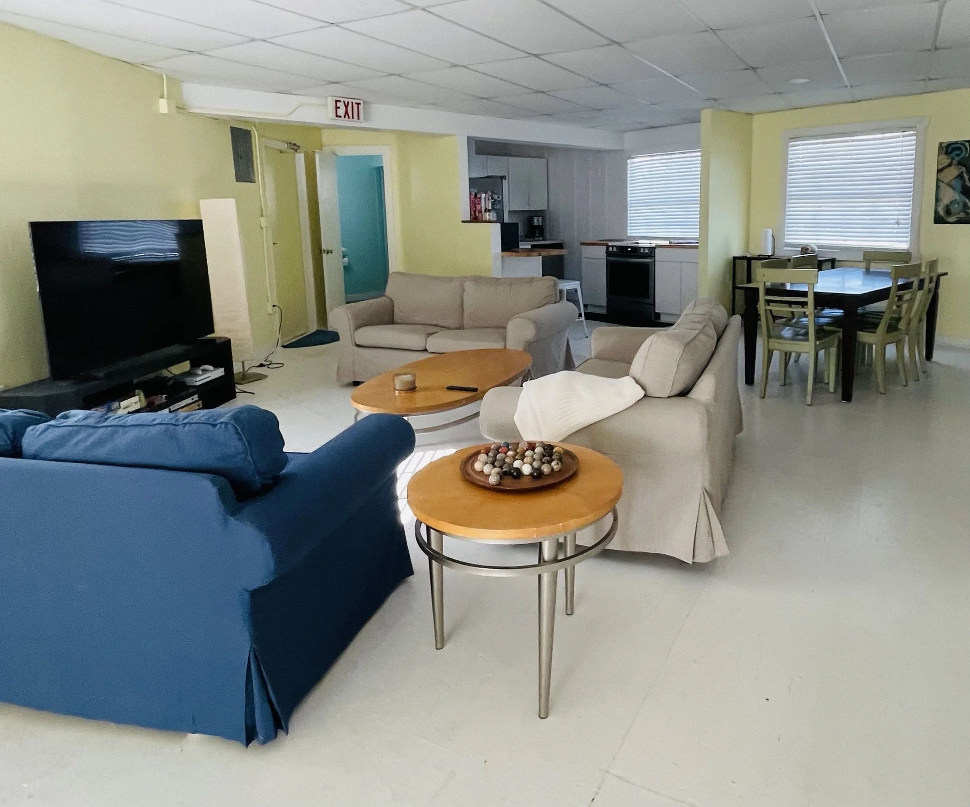 The living room with sofas, a TV and the dining table